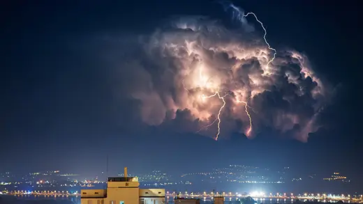 Storm with lightning over the city at night