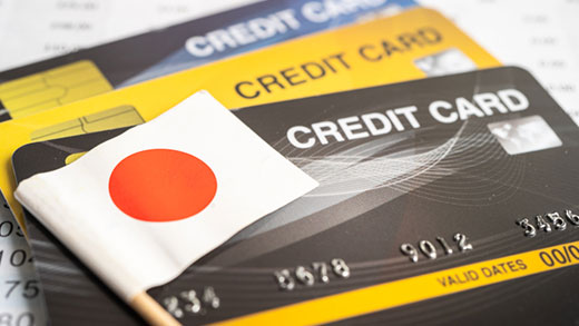 Foto de tarjetas de crédito y una pequeña bandera japonesa que representa los servicios financieros en Japón