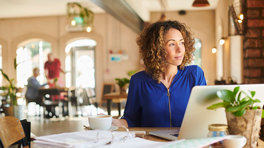 Frau arbeitet in einem Café an ihrem Laptop